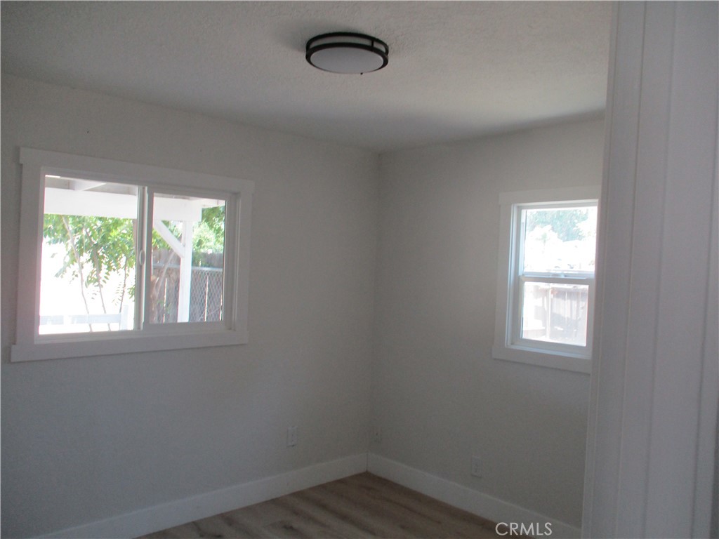 28584 Goetz Road Menifee, CA 92587 - Photo 5 of 10 an empty room with wooden floor and windows
