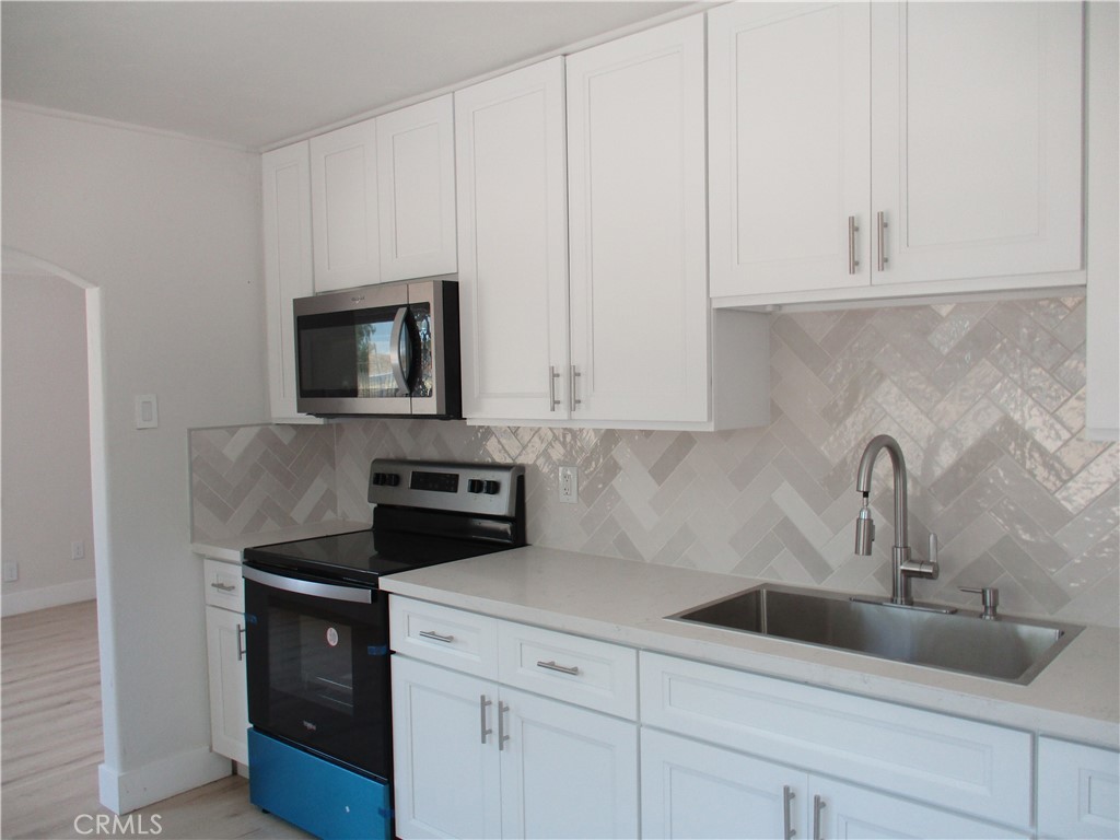 28584 Goetz Road Menifee, CA 92587 - Photo 10 of 10 a kitchen with white cabinets and stainless steel appliances
