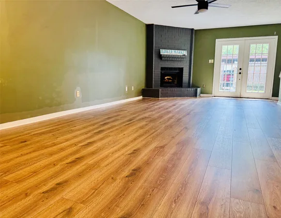 a view of a livingroom with wooden floor and a fireplace