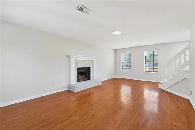 a view of empty room with wooden floor and fireplace
