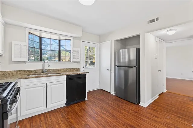 a kitchen with stainless steel appliances granite countertop a refrigerator and a sink