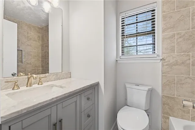 a bathroom with a toilet a sink and mirror