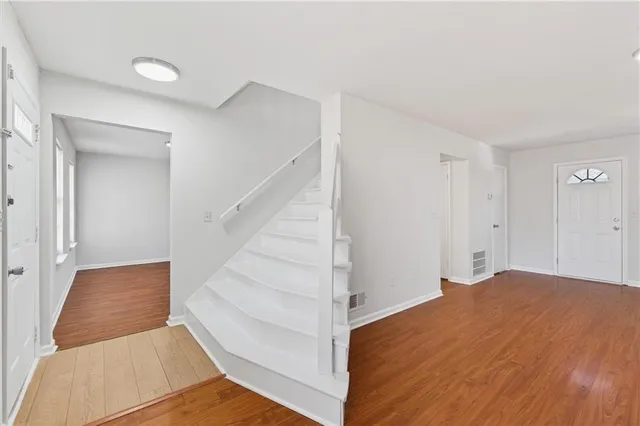 a view of an empty room with stairs and a ceiling fan