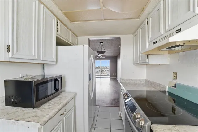 a kitchen with stainless steel appliances granite countertop a sink a stove and a refrigerator