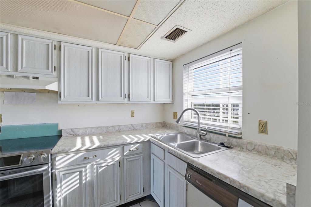 4939 Floramar Terrace, Unit 712 New Port Richey, FL 34652 - Photo 14 of 41 a kitchen with a sink cabinets and window