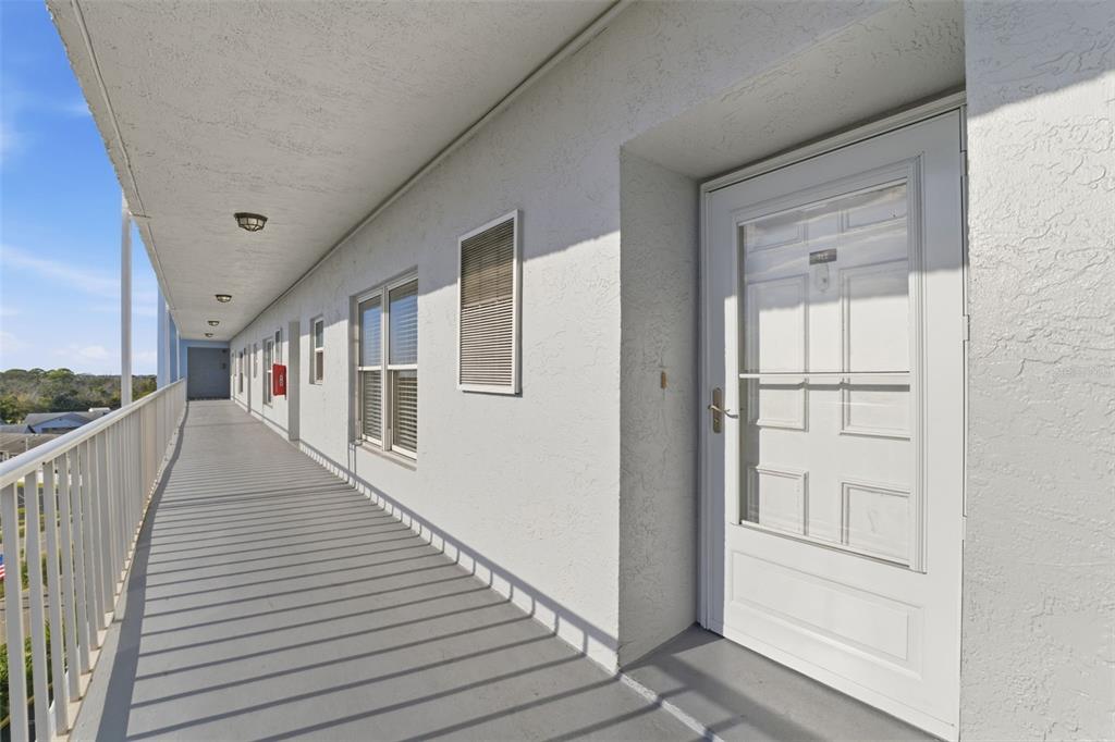 4939 Floramar Terrace, Unit 712 New Port Richey, FL 34652 - Photo 3 of 41 a view of a hallway with wooden floor and staircase