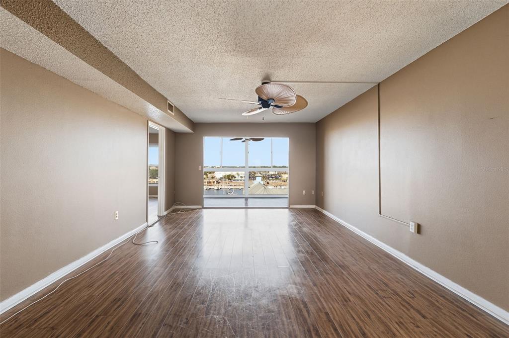 4939 Floramar Terrace, Unit 712 New Port Richey, FL 34652 - Photo 5 of 41 a view of an empty room with a window and wooden floor