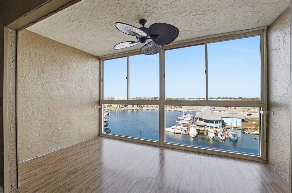 4939 Floramar Terrace, Unit 712 New Port Richey, FL 34652 - Photo 8 of 41 a view of a living room with a floor to ceiling window and wooden floor