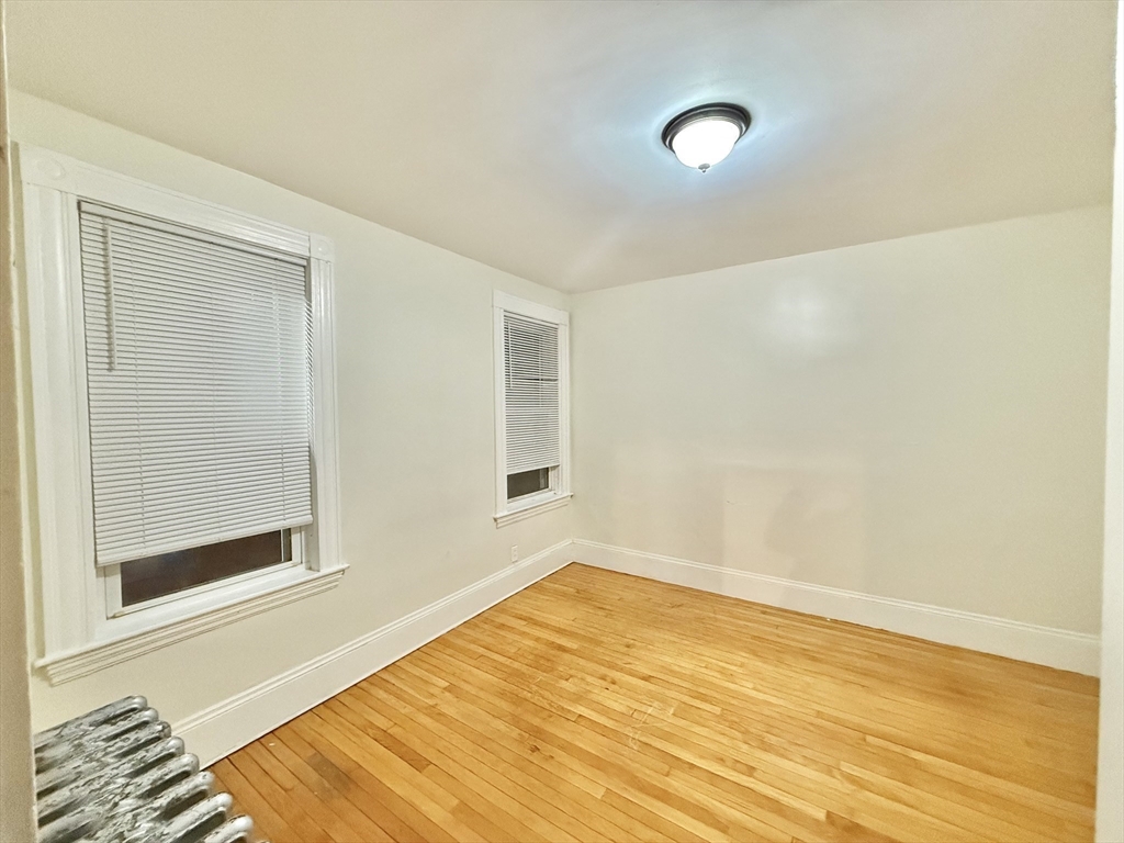 23 Pearl Street, Unit 1 Everett, MA 02149 - Photo 11 of 13 a view of a room with wooden floor and white walls