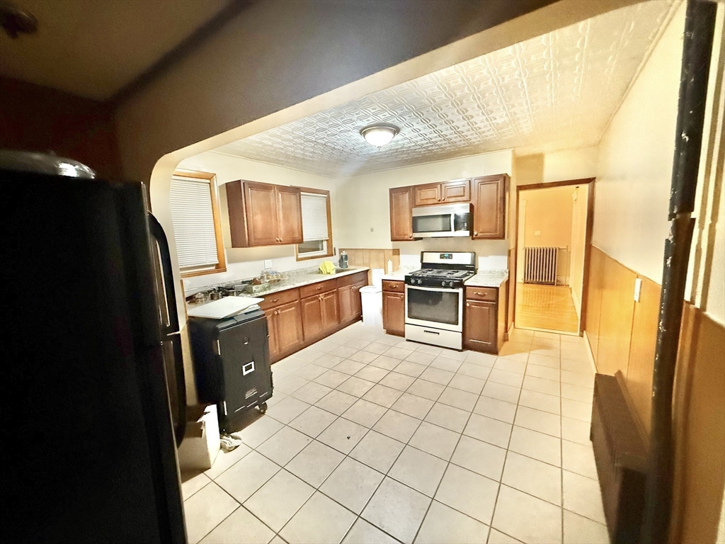 23 Pearl Street, Unit 1 Everett, MA 02149 - Photo 13 of 13 a kitchen with stainless steel appliances granite countertop a sink stove and refrigerator