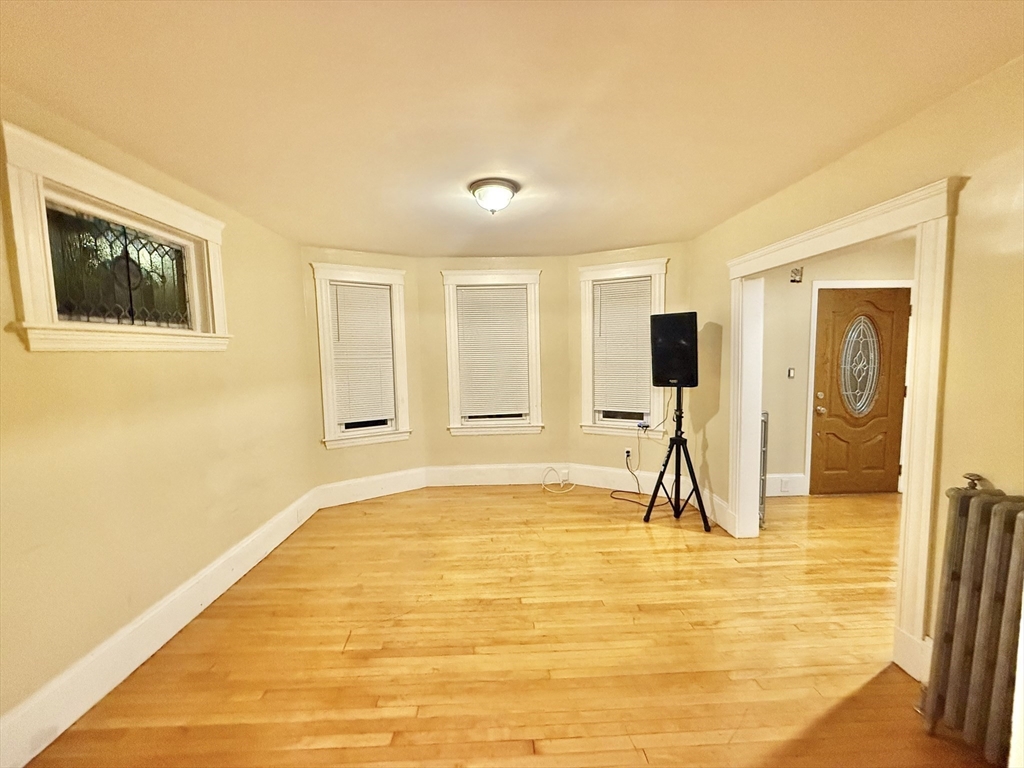 23 Pearl Street, Unit 1 Everett, MA 02149 - Photo 4 of 13 a living room with a large window and a flat screen tv