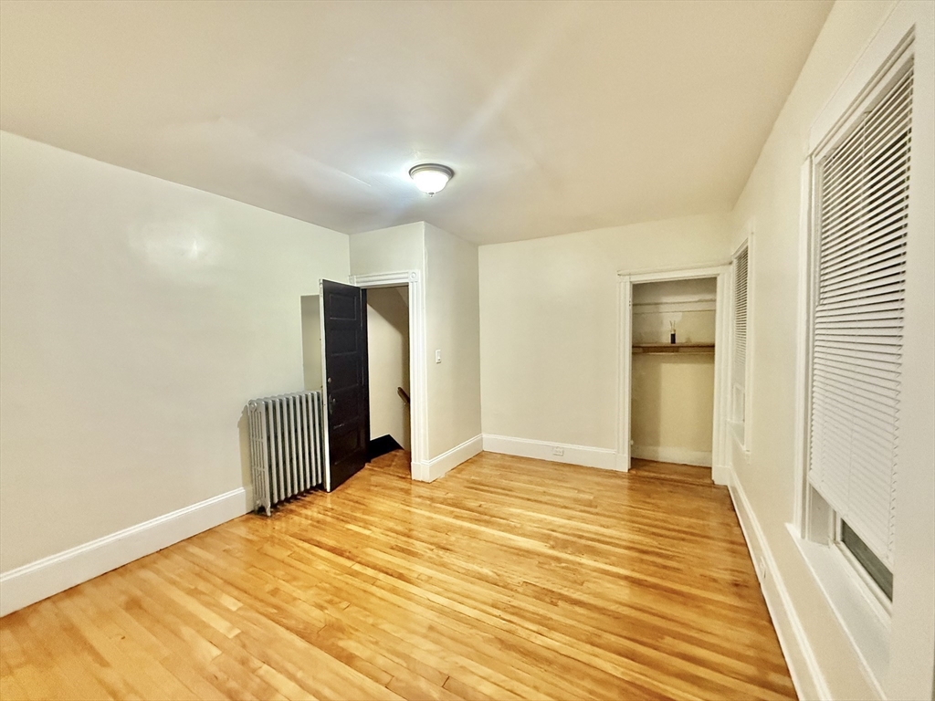 23 Pearl Street, Unit 1 Everett, MA 02149 - Photo 8 of 13 a bedroom with a bed and wooden floor