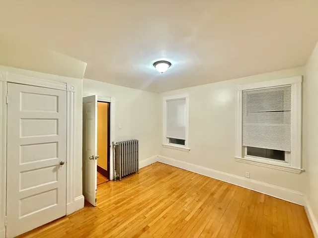 a view of a room with wooden floor and white walls