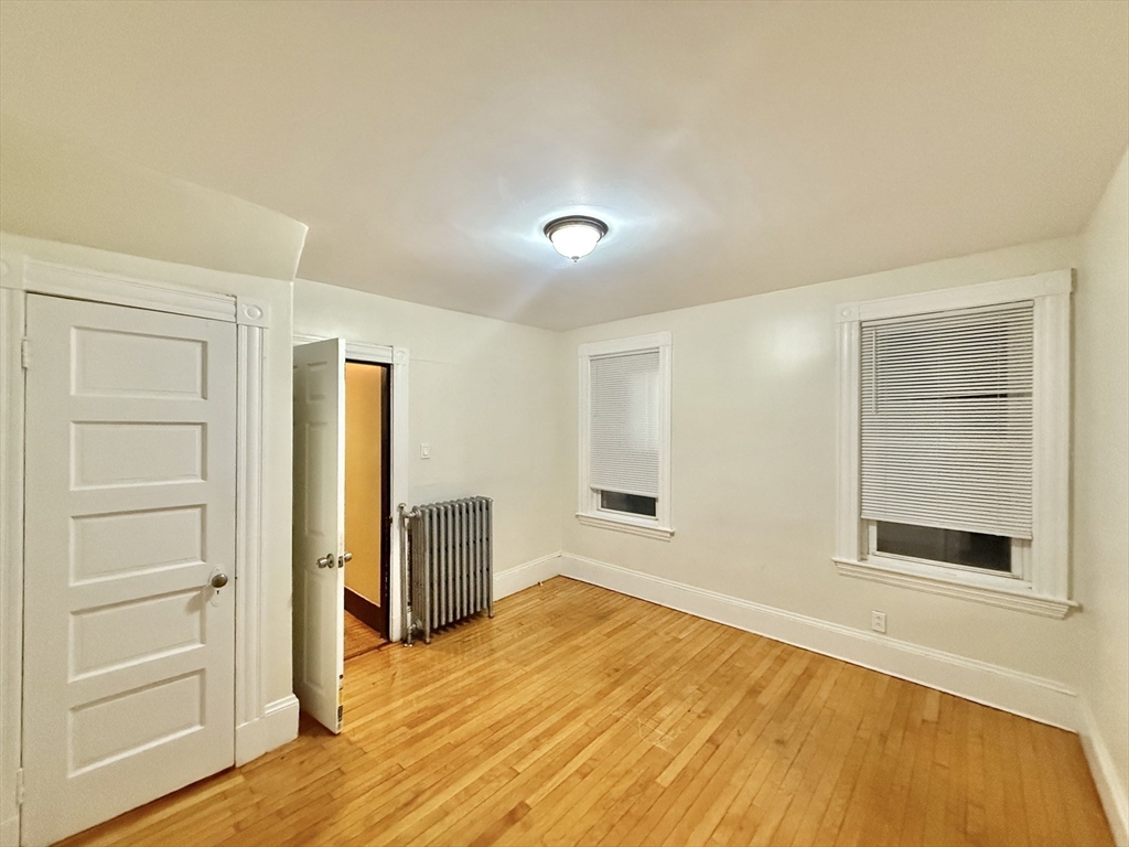 23 Pearl Street, Unit 1 Everett, MA 02149 - Photo 9 of 13 a view of an empty room with wooden floor and a window