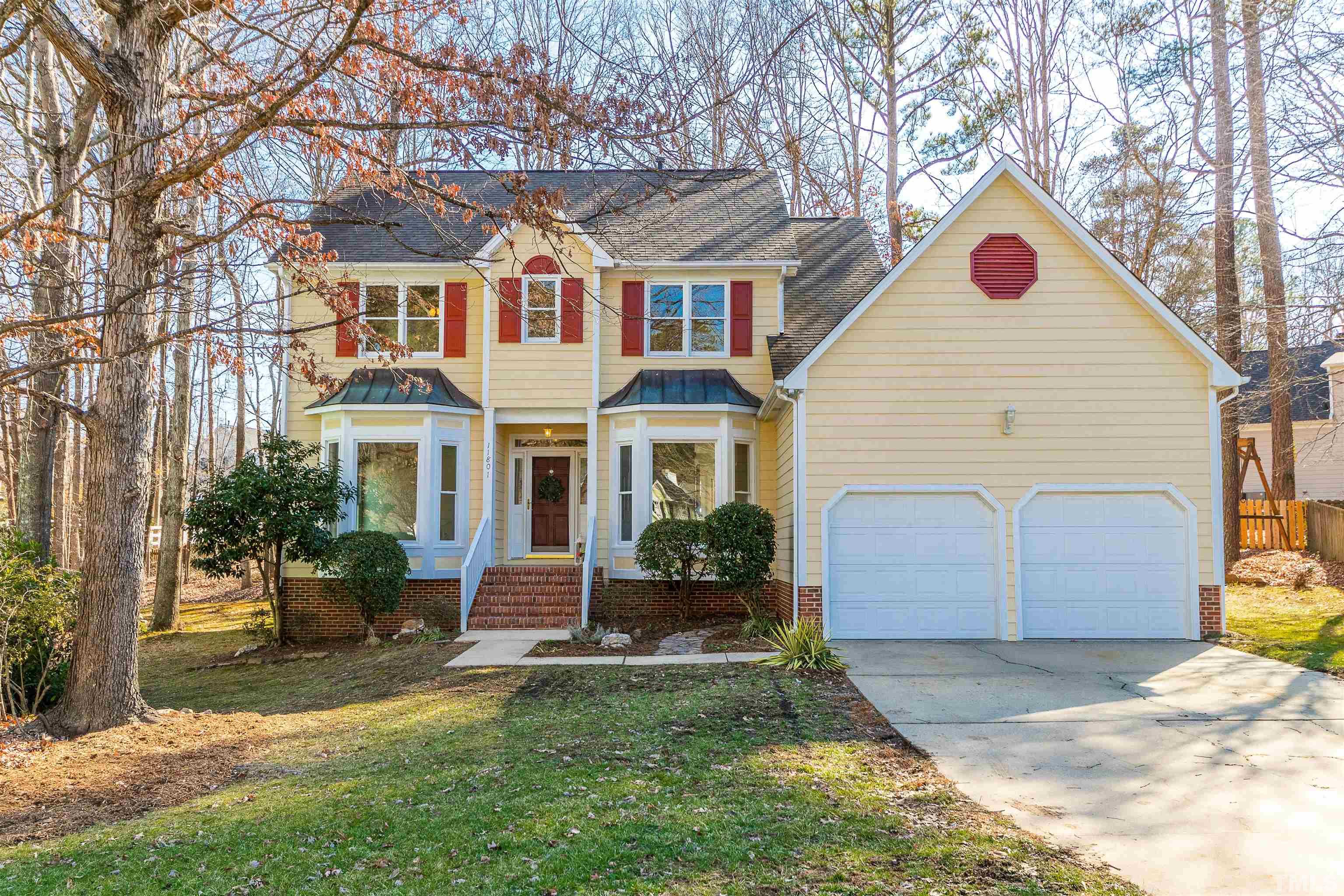 11801 Fairlie Place Raleigh, NC 27613 - Photo 1 of 32 a front view of a house with a yard and garage