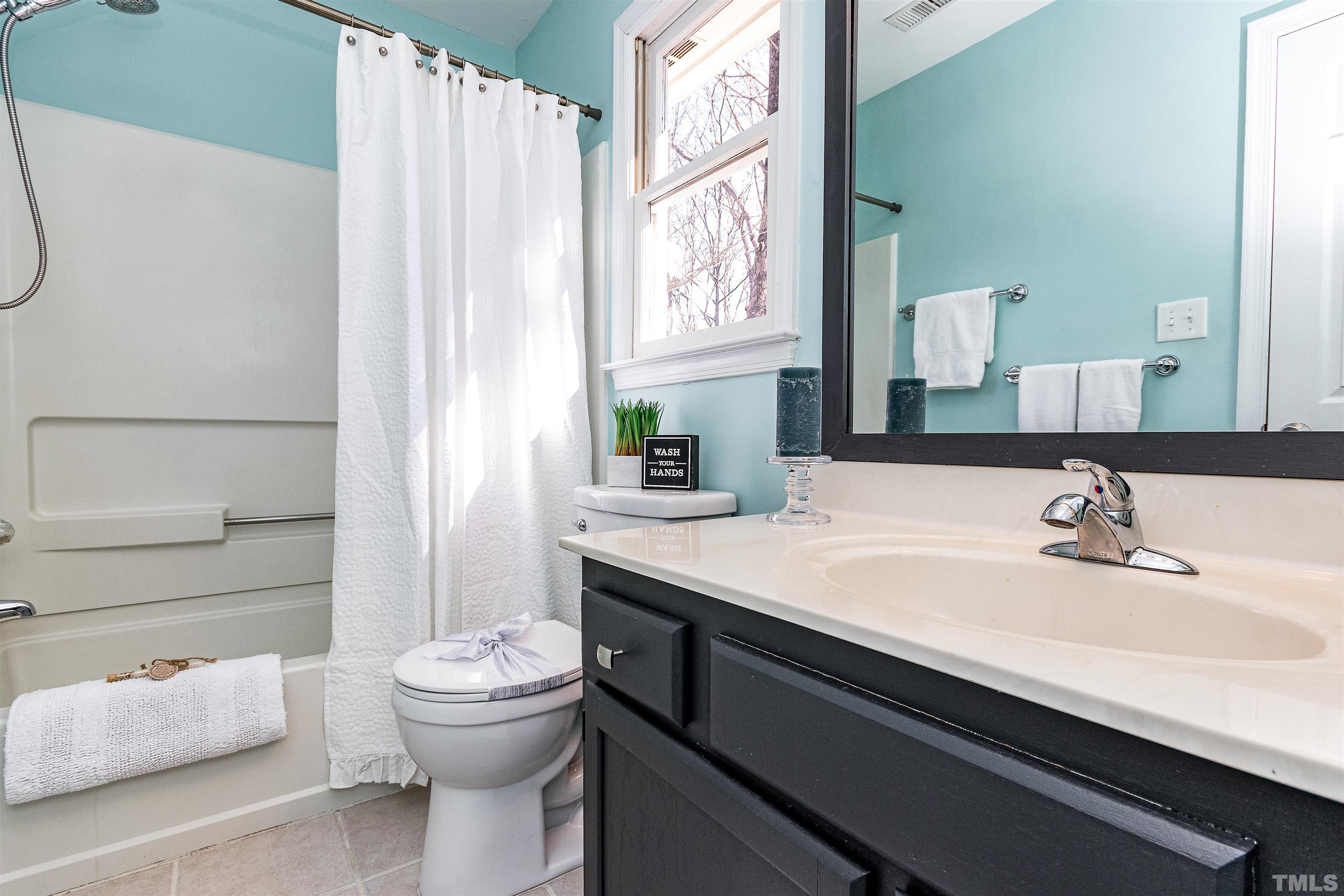 11801 Fairlie Place Raleigh, NC 27613 - Photo 16 of 32 a bathroom with a sink a toilet and shower