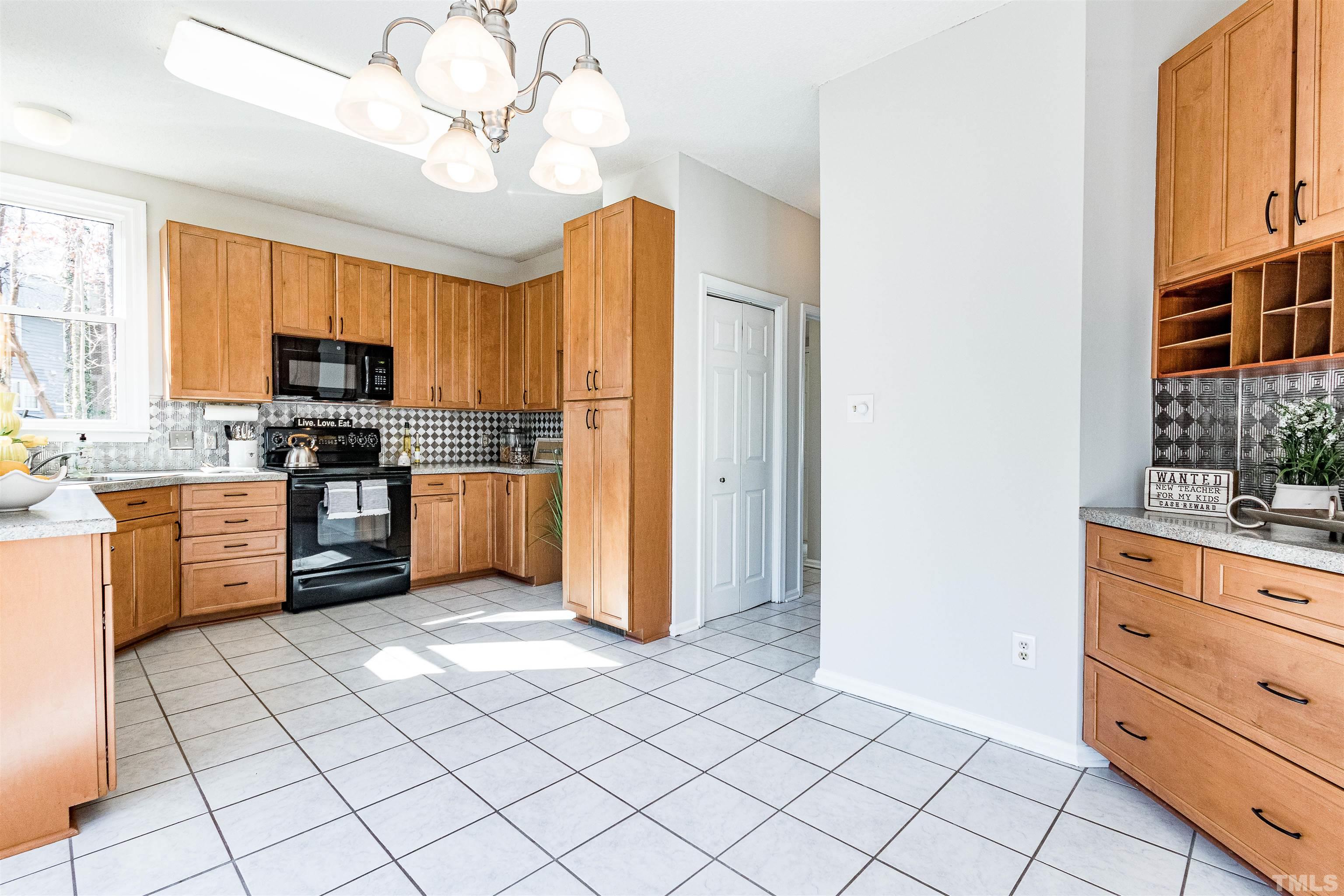 11801 Fairlie Place Raleigh, NC 27613 - Photo 5 of 32 a kitchen with stainless steel appliances granite countertop a stove top oven a sink dishwasher and a refrigerator with wooden floor