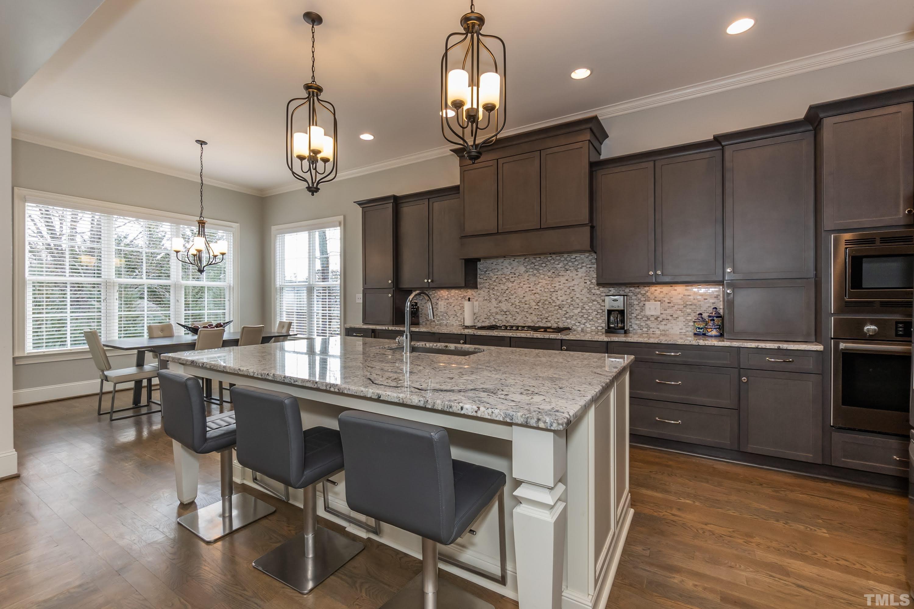 6418 Rosny Road Raleigh, NC 27613 - Photo 13 of 52 a kitchen with kitchen island granite countertop a sink a counter space appliances and cabinets