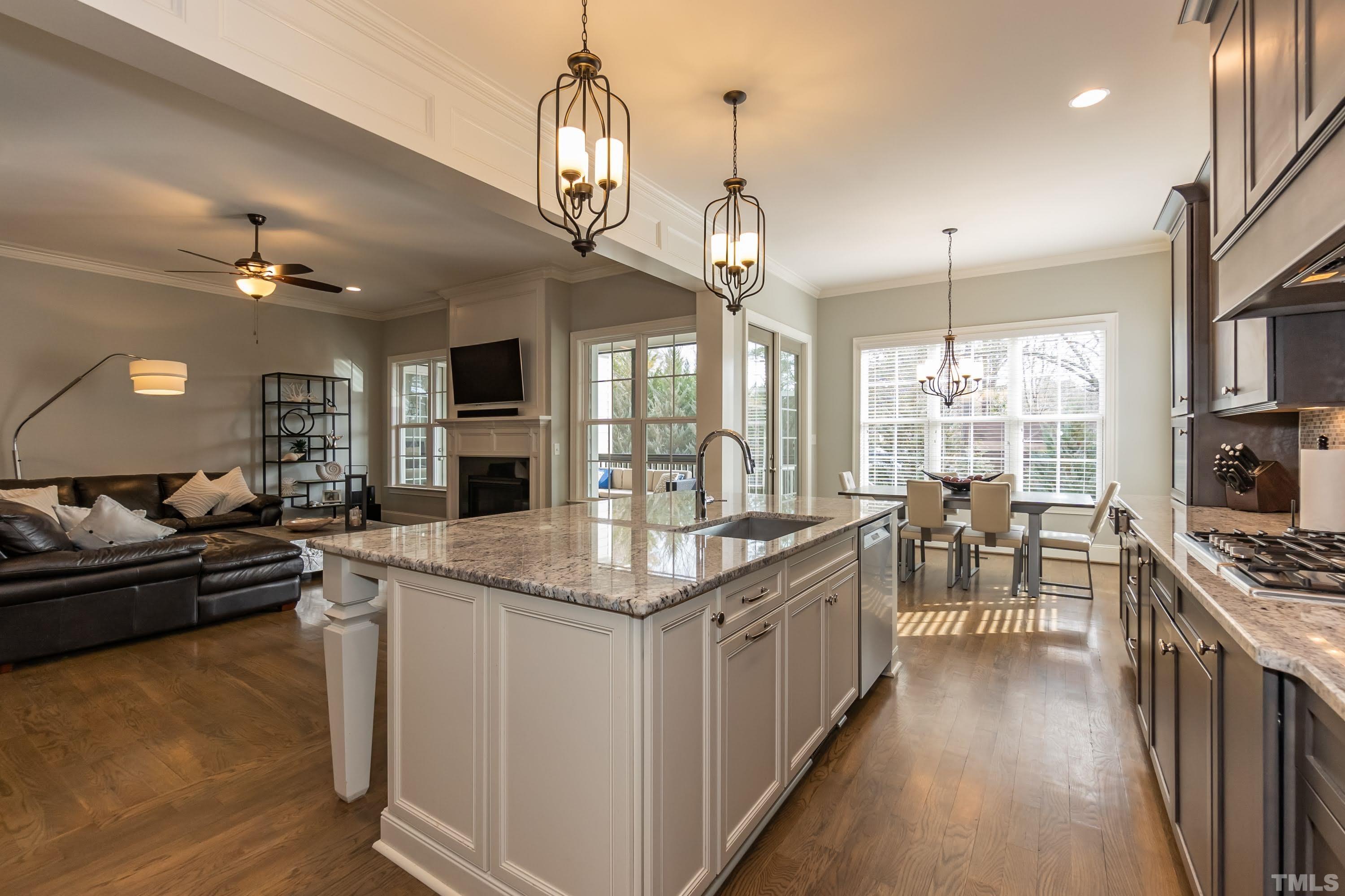6418 Rosny Road Raleigh, NC 27613 - Photo 16 of 52 a kitchen with stainless steel appliances granite countertop a stove oven and a view of dining hall with couches