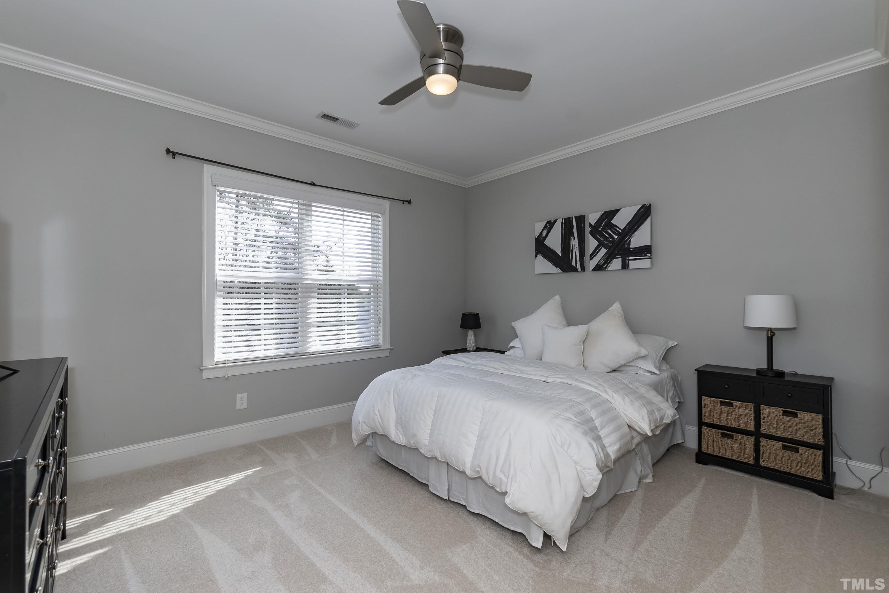 6418 Rosny Road Raleigh, NC 27613 - Photo 35 of 52 a spacious bedroom with a bed painting on wall and a large window
