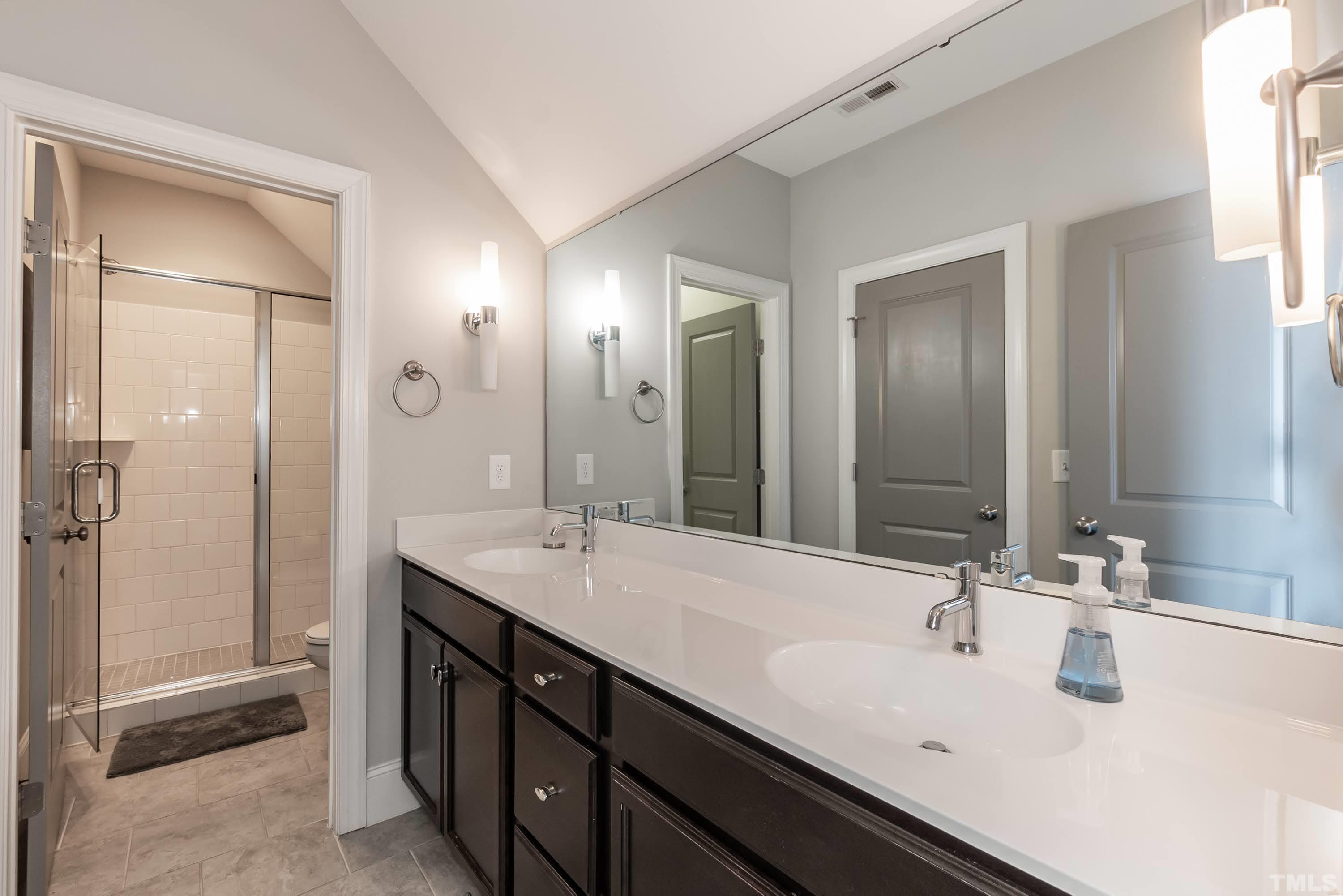 6418 Rosny Road Raleigh, NC 27613 - Photo 39 of 52 a bathroom with a sink double vanity and a mirror