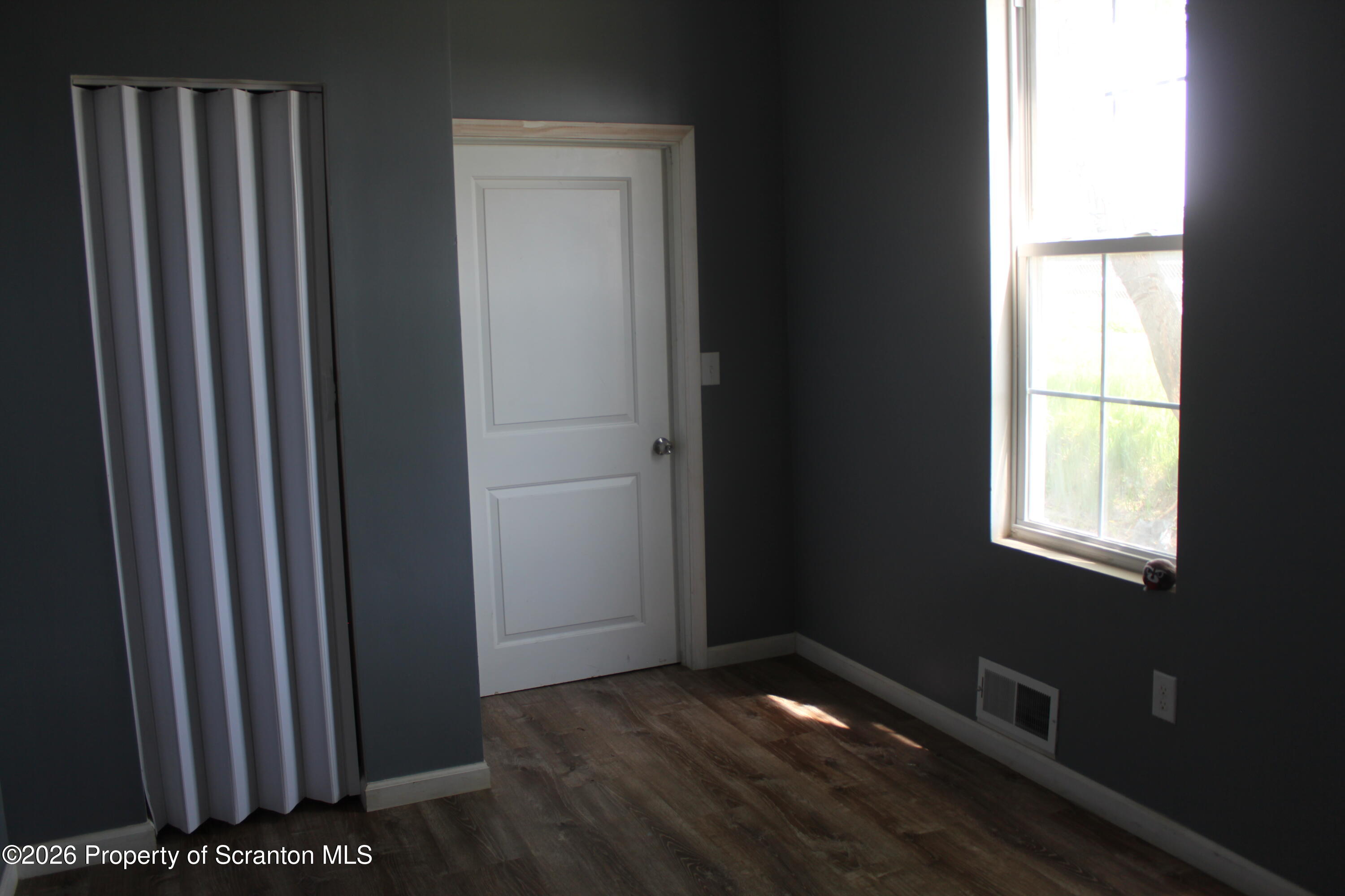 1122 Luzerne Street, Unit A Scranton, PA 18504 - Photo 9 of 13 a view of an empty room with wooden floor and a window