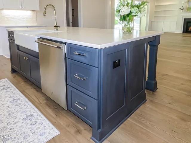 an empty room with chandelier fan and windows