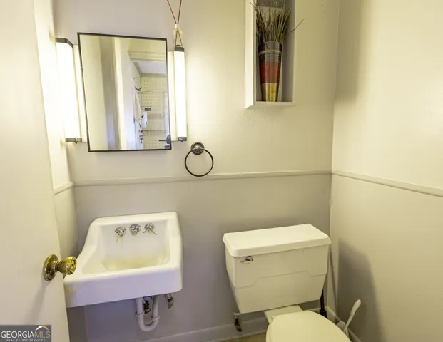 a bathroom with a toilet sink and mirror