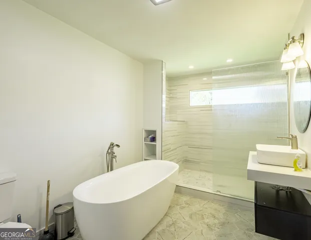 a white bath tub sitting next to a white toilet