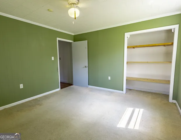 a view of an empty room with a chandelier fan
