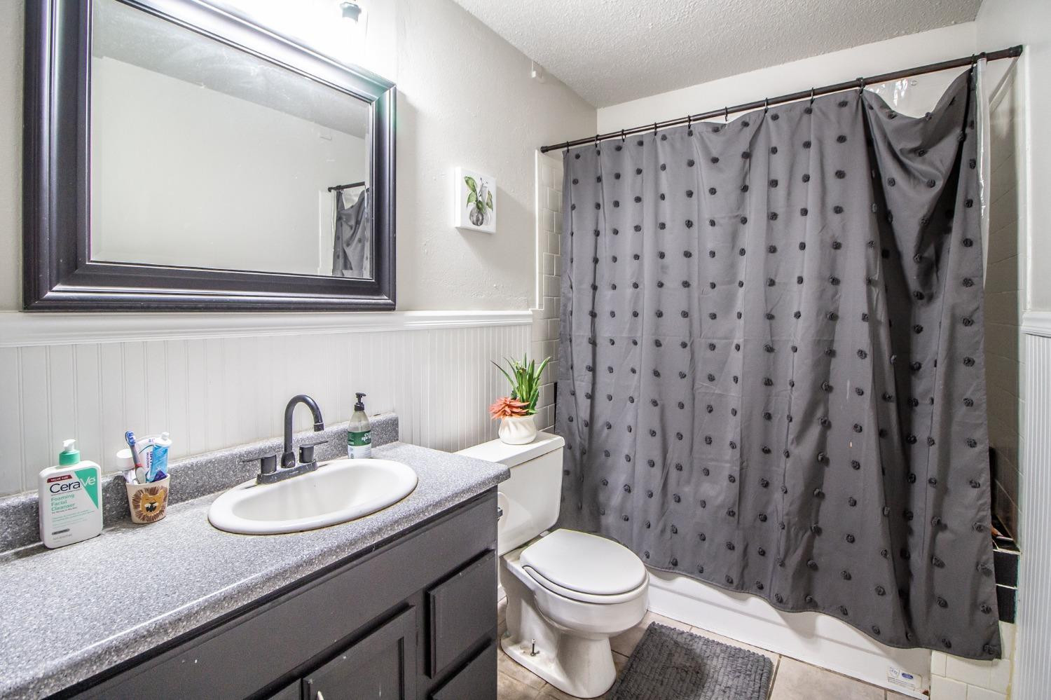 5411 32nd Street Lubbock, TX 79407 - Photo 18 of 22 a bathroom with a granite countertop sink and a mirror