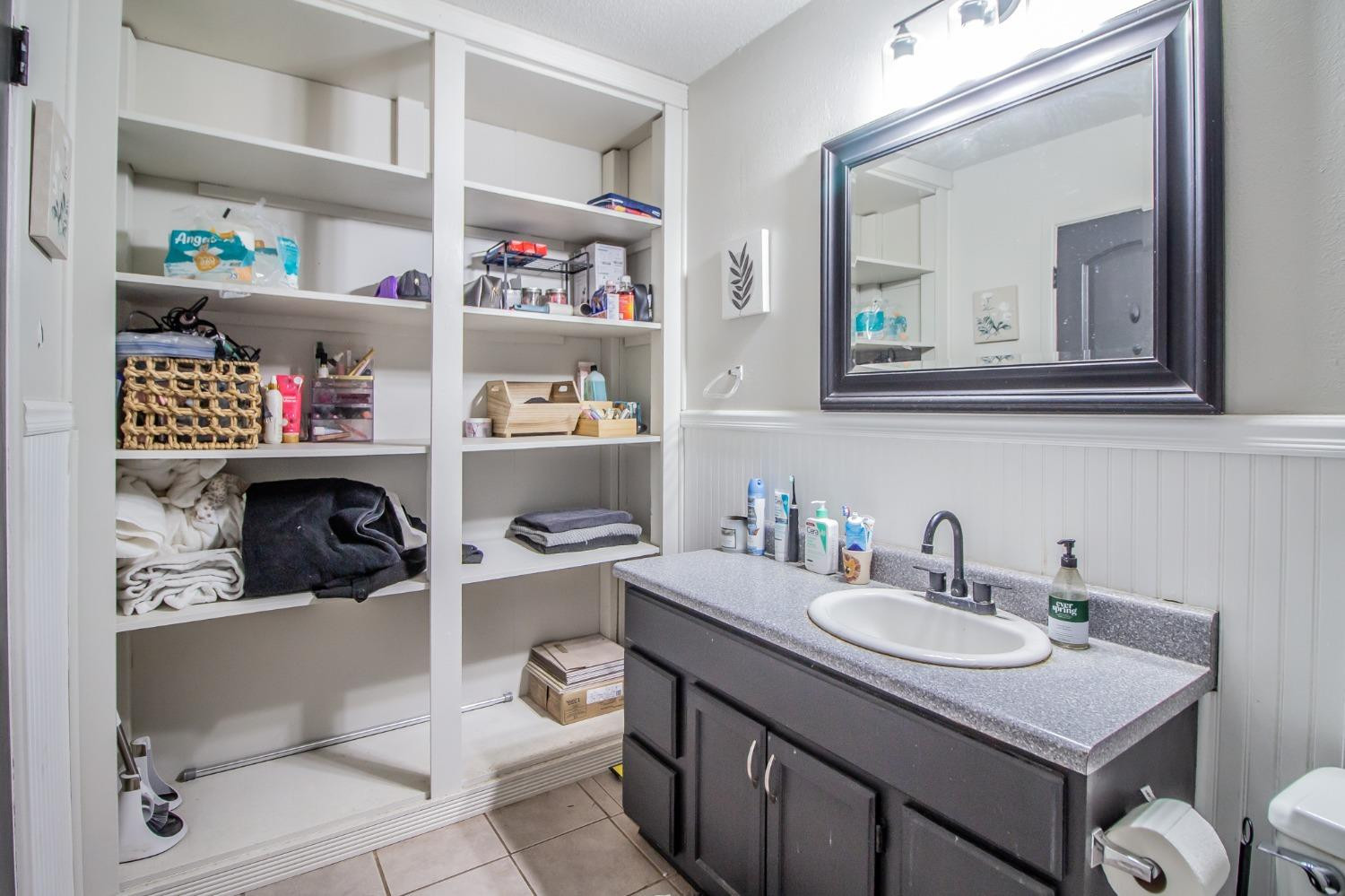 5411 32nd Street Lubbock, TX 79407 - Photo 19 of 22 a bathroom with a sink vanity and a mirror
