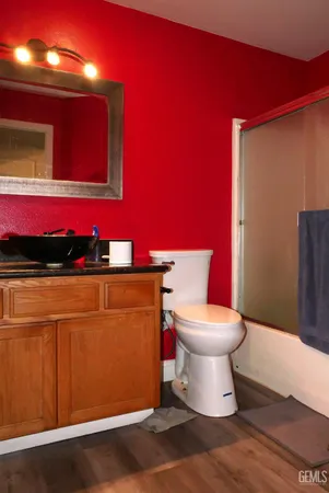 a bathroom with a toilet a sink and mirror