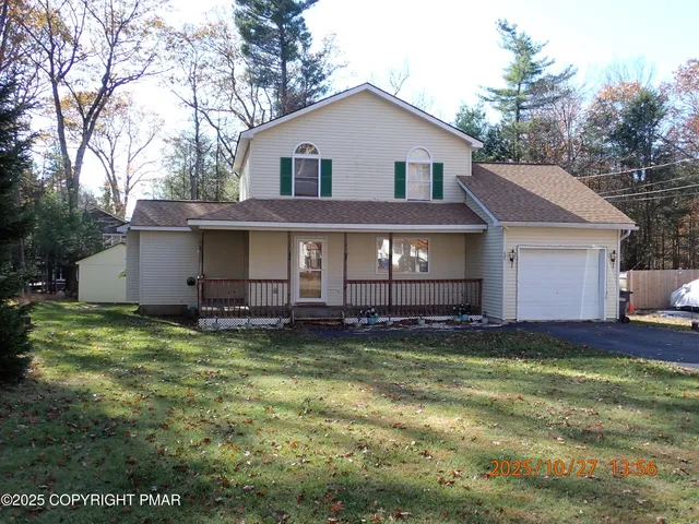 a view of a house with a yard and large tree