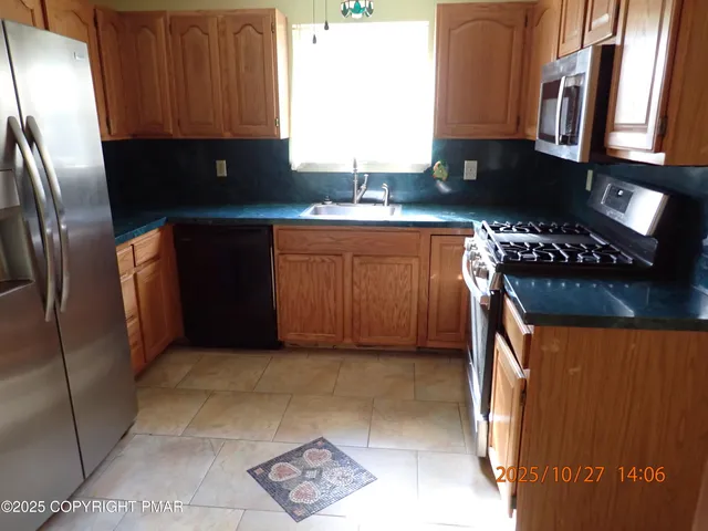 a kitchen with stainless steel appliances granite countertop a refrigerator and a stove