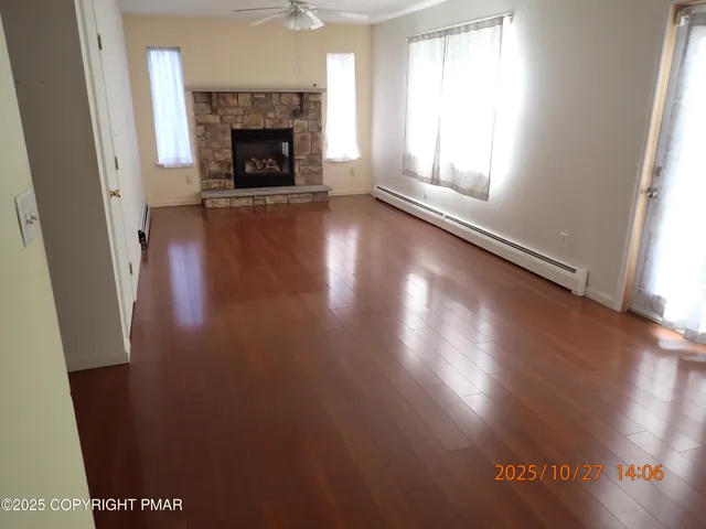 an empty room with wooden floor and fireplace