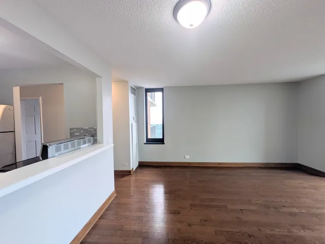 a view of a big room with wooden floor and windows