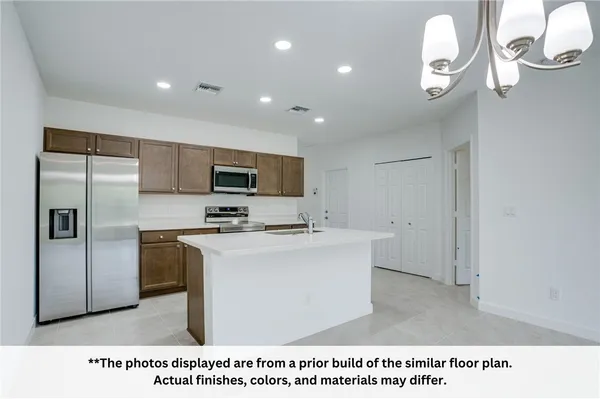 a kitchen with a refrigerator a stove top oven a sink and dishwasher
