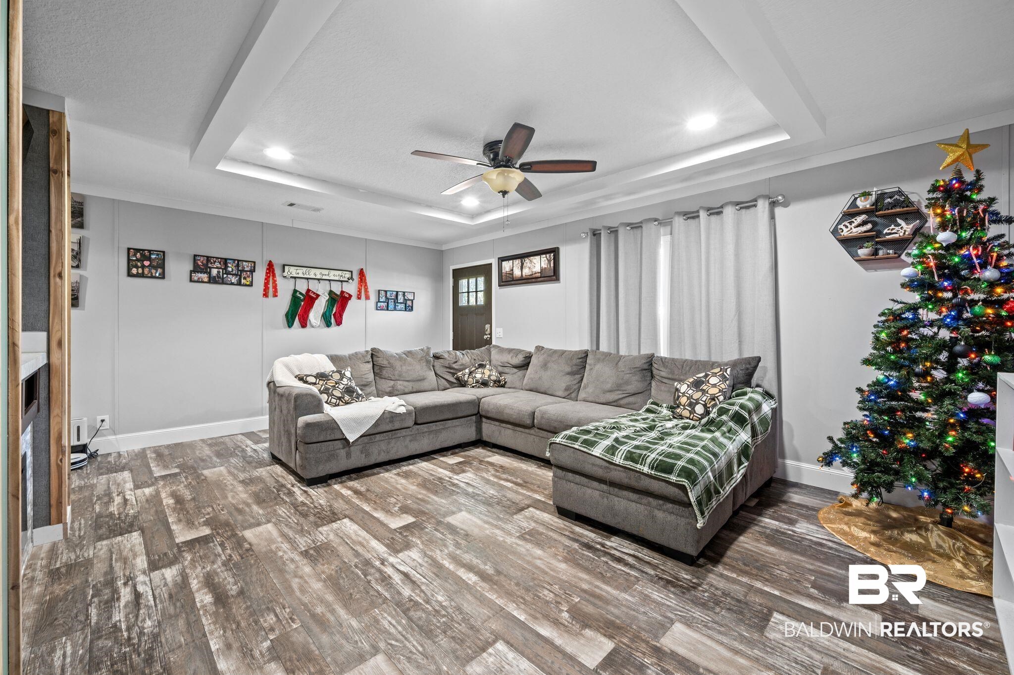 9382 D'Olive Street Bay Minette, AL 36507 - Photo 2 of 27 Living room featuring a raised ceiling, ceiling fan, and hardwood / wood-style floors