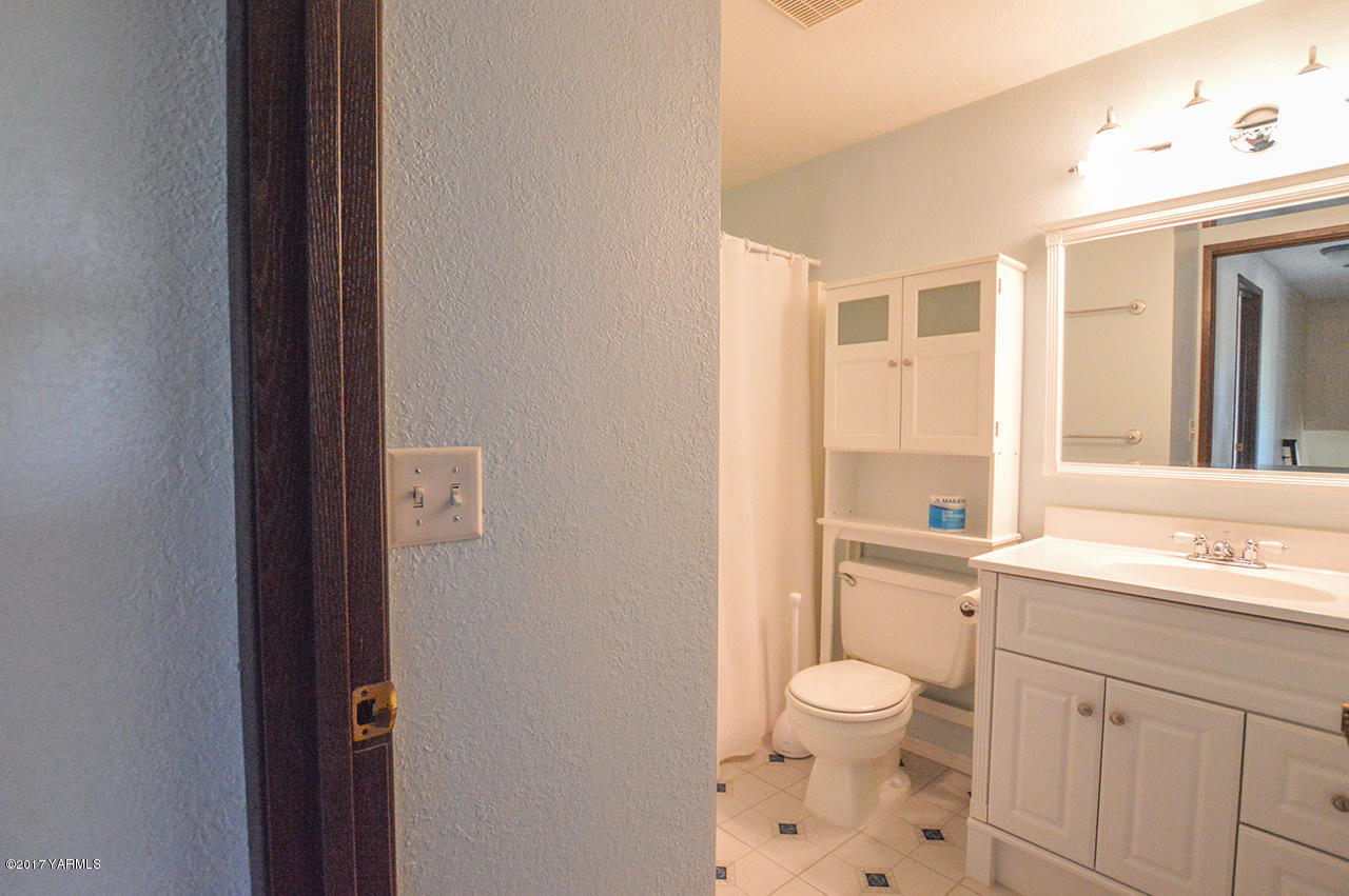 10820 Mieras Road Yakima, WA 98901 - Photo 21 of 21 a bathroom with a granite countertop toilet a sink and a mirror