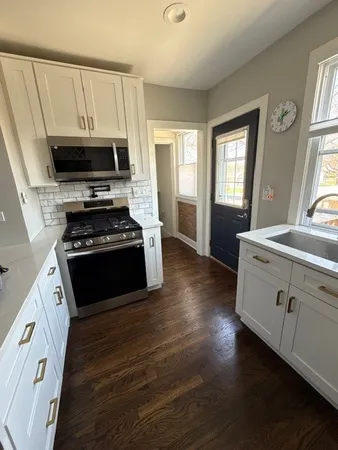 a kitchen with wooden floors and white appliances
