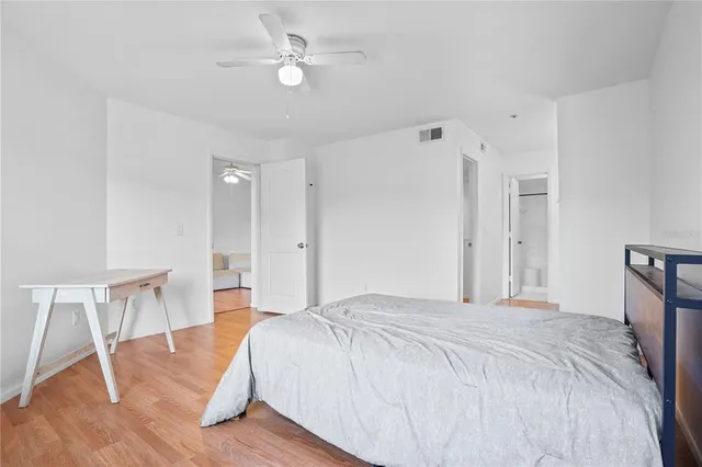 a spacious bedroom with a bed and a table chair