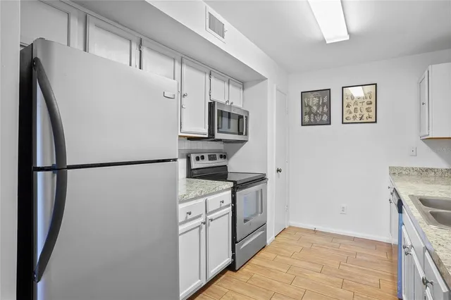 a kitchen with stainless steel appliances a refrigerator sink and microwave