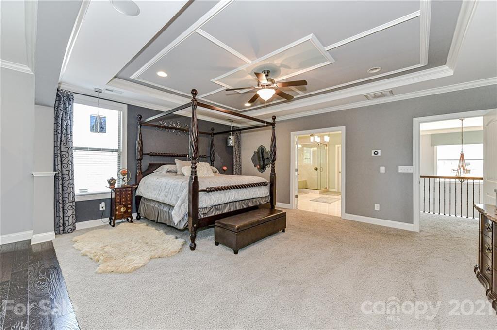 2756 Collaroy Road Waxhaw, NC 28173 - Photo 25 of 48 a bedroom with a bed and a chandelier