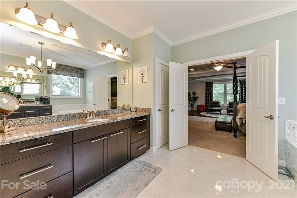 2756 Collaroy Road Waxhaw, NC 28173 - Photo 28 of 48 a spacious en suite bathroom with a granite countertop sink mirror and bathtub