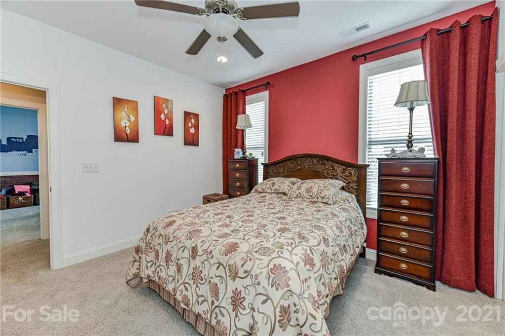 2756 Collaroy Road Waxhaw, NC 28173 - Photo 29 of 48 a bedroom with a bed and a chandelier