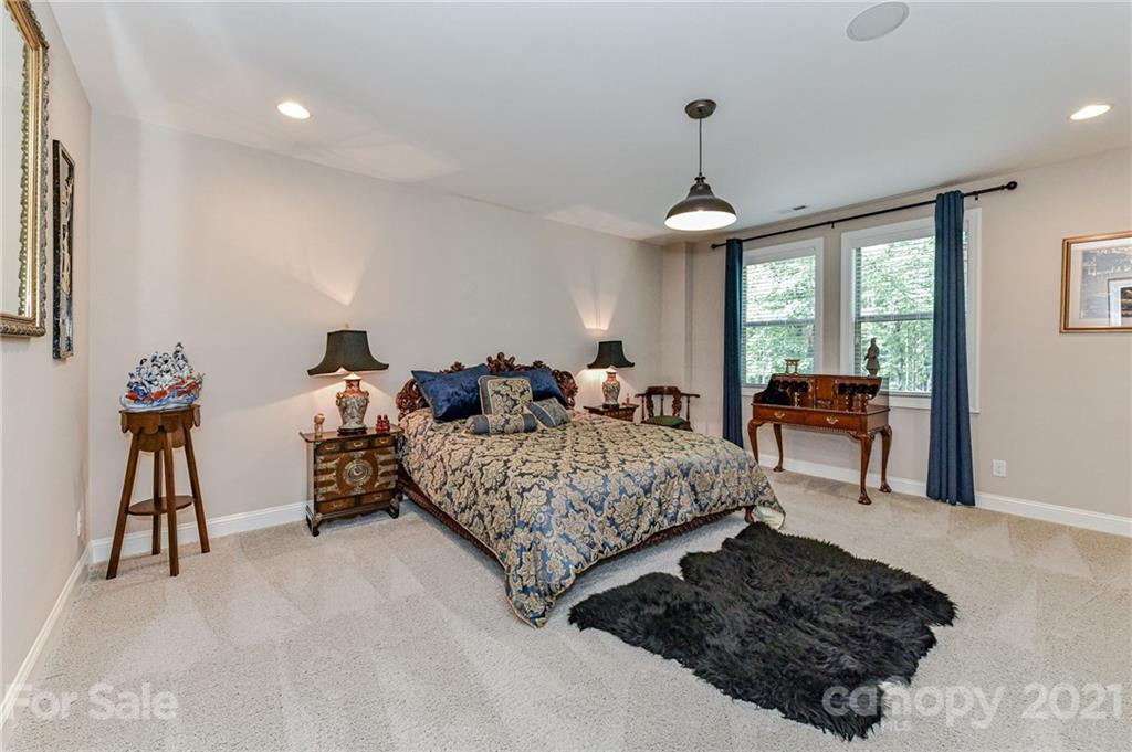 2756 Collaroy Road Waxhaw, NC 28173 - Photo 40 of 48 a bed room with a bed and a chandelier