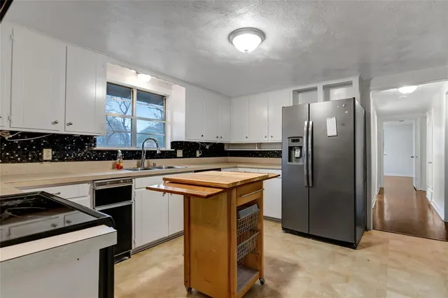 a kitchen with stainless steel appliances granite countertop a stove a refrigerator a sink and dishwasher