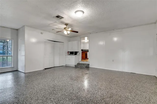 an empty room with a empty space and a ceiling fan