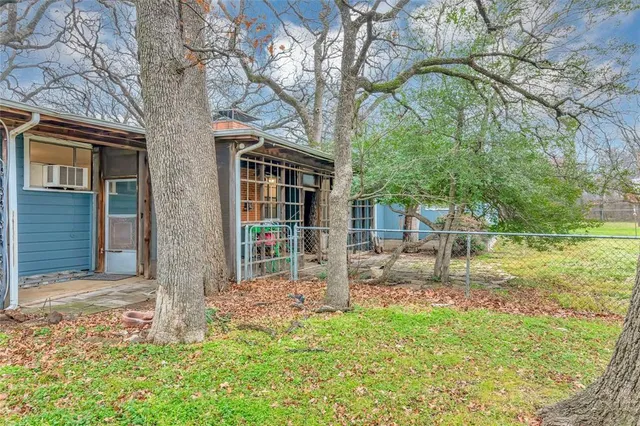 a brick house with a yard and large tree